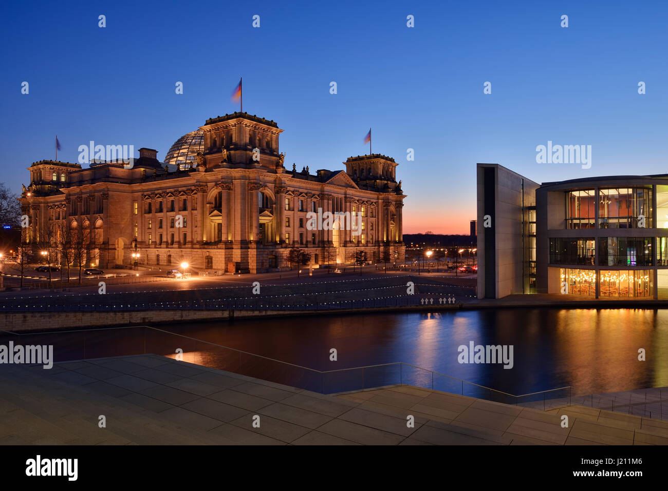 Regierungsgebäude beleuchtet der Reichstag und das Paul-Löbe-Haus im Regierungsviertel (Bundestag) in der Abenddämmerung, Berlin-Mitte Spree entlang. Reichst Stockfoto