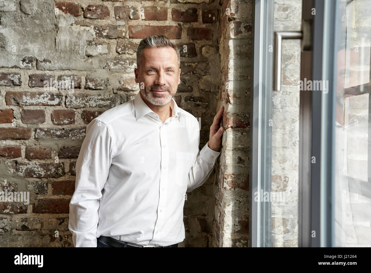 Porträt von zuversichtlich Geschäftsmann an eine Mauer gelehnt Stockfoto