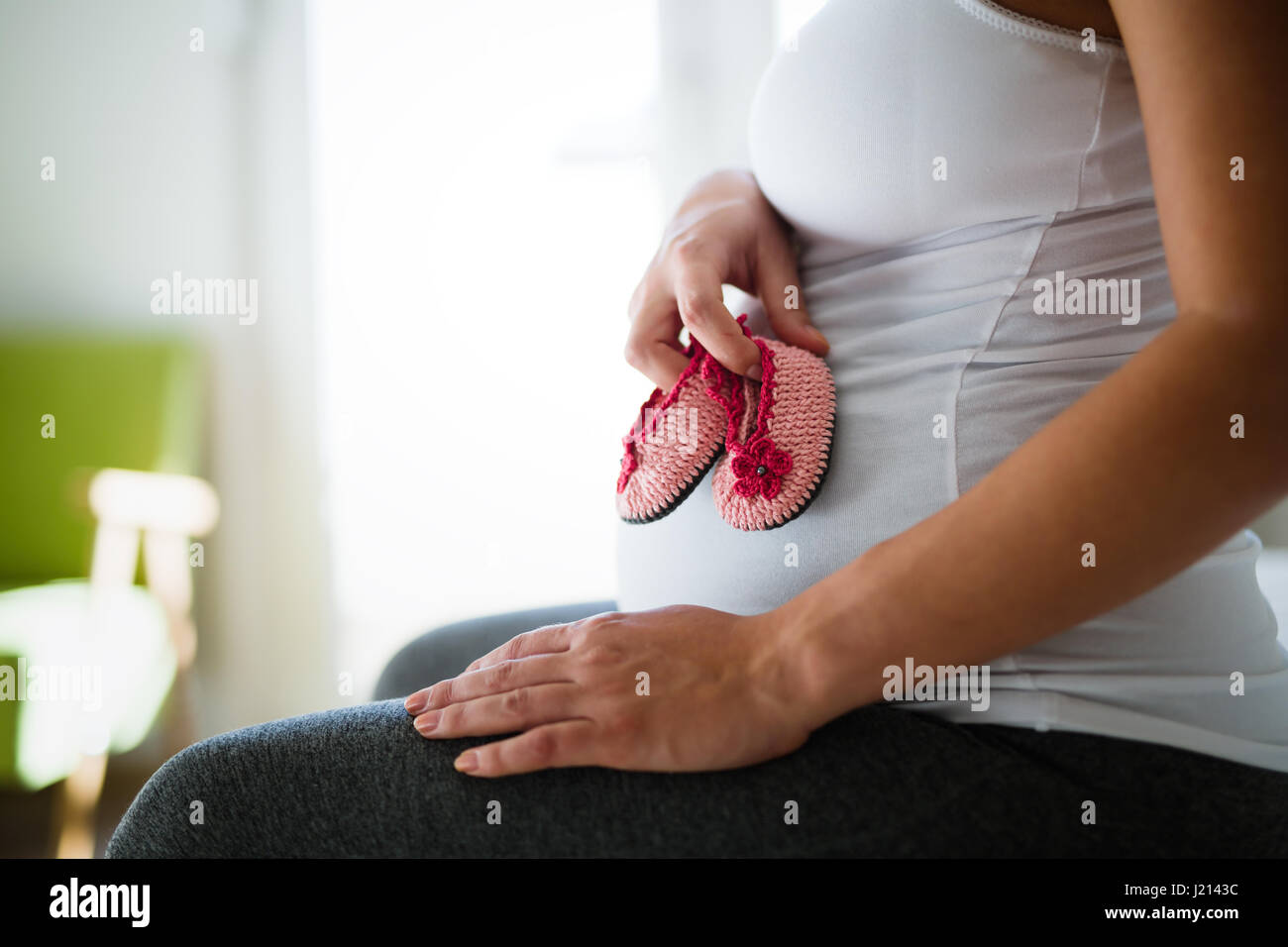 Schwangere werdende Mutter mit niedlichen kleinen Baby-Schuhe Stockfoto