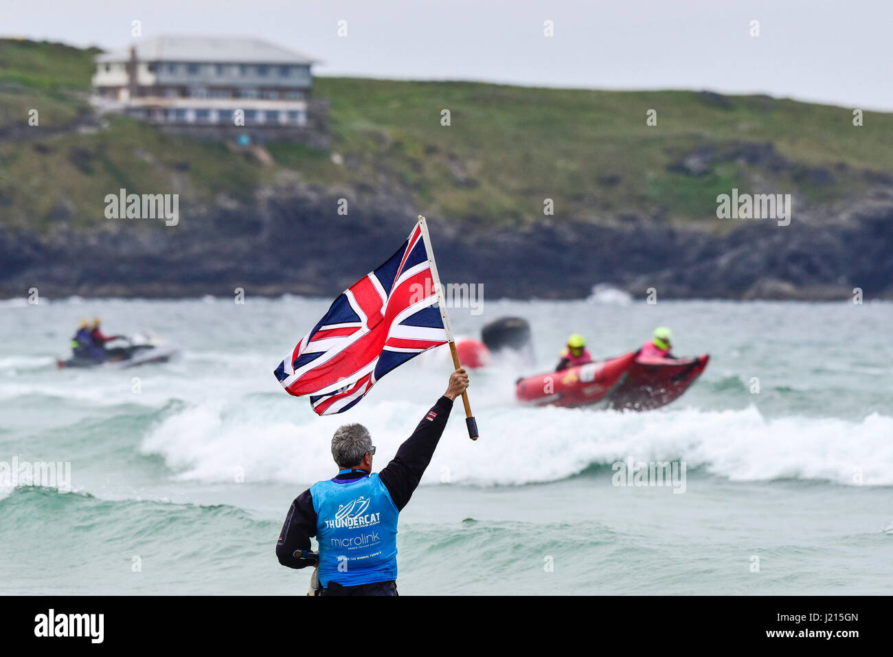 Thundercat Racing UK Race Mann winkt Union Jack Flag Flaggensignal Signalisierung Meer Fistral Strand Newquay Cornwall Stockfoto