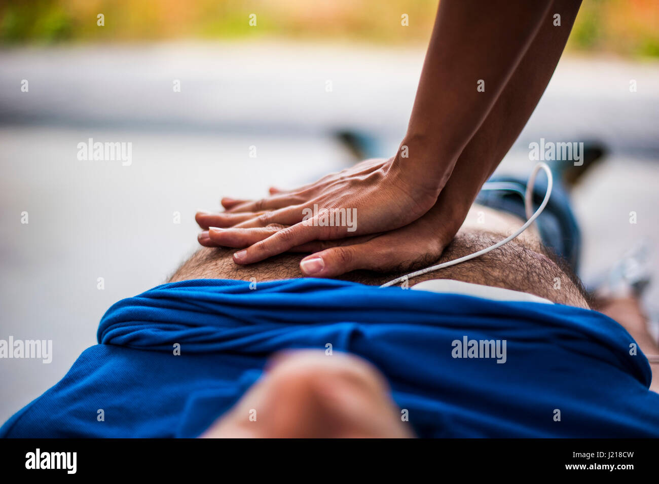 ein Mädchen hilft einen Kerl nach dem Herzinfarkt mit Reanimation Stockfoto