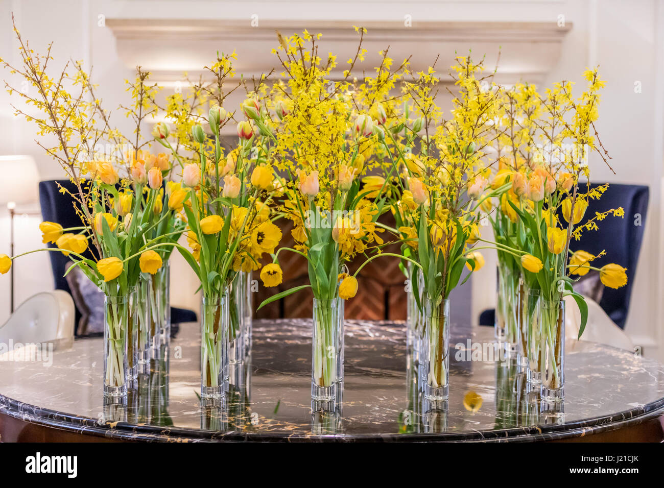wunderschöne gelbe Blumen in Glasvasen in einem Londoner Hotel-lobby Stockfoto