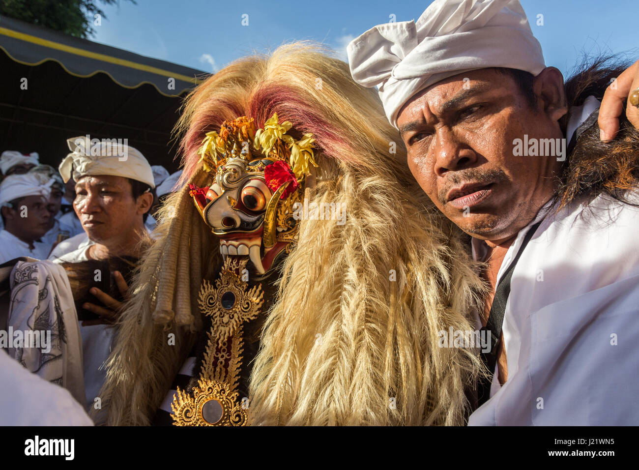 Kesiman, Denpasar, Bali, Indonesien. 23. April 2017. Balinesische Mann hilft Rangda die Dämon-Königin der Hexen während der Trance bei Messer-Ritual der Sakral an der Pengerebongan-Zeremonie selbst. Dieses Ritual findet alle 210 Tage auf dem hinduistischen Balinesen Saka-Kalender die Gebete und Opfergaben, eine Parade von mythologischen Figuren, Männer und Frauen in Trance mit einigen Männern, die versuchen, ihre Haut mit einem traditionellen Keris (Messer) durchbohren mit sich bringt, zum Glück niemand wird verletzt bei dieser unglaublichen balinesische Zeremonie in Pura Petilan Tempel, Denpasar, Indonesien. Bildnachweis: Antony Ratcliffe/Alamy Li Stockfoto