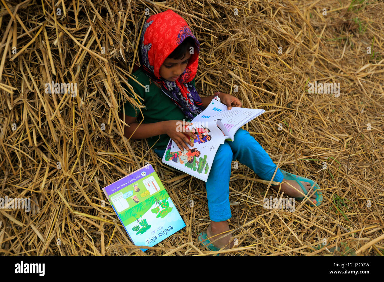 Grundschule Student liest ein neues Buch, als sie ihre neue Lehrbücher für neue Klasse in der Singair wird. Manikganj, Bangladesch Stockfoto