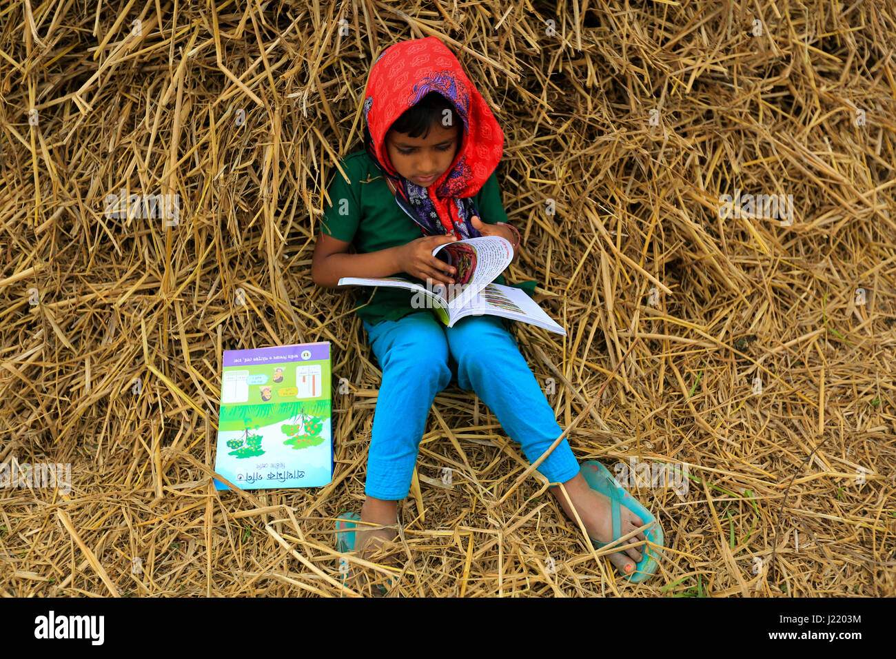 Grundschule Student liest ein neues Buch, als sie ihre neue Lehrbücher für neue Klasse in der Singair wird. Manikganj, Bangladesch Stockfoto
