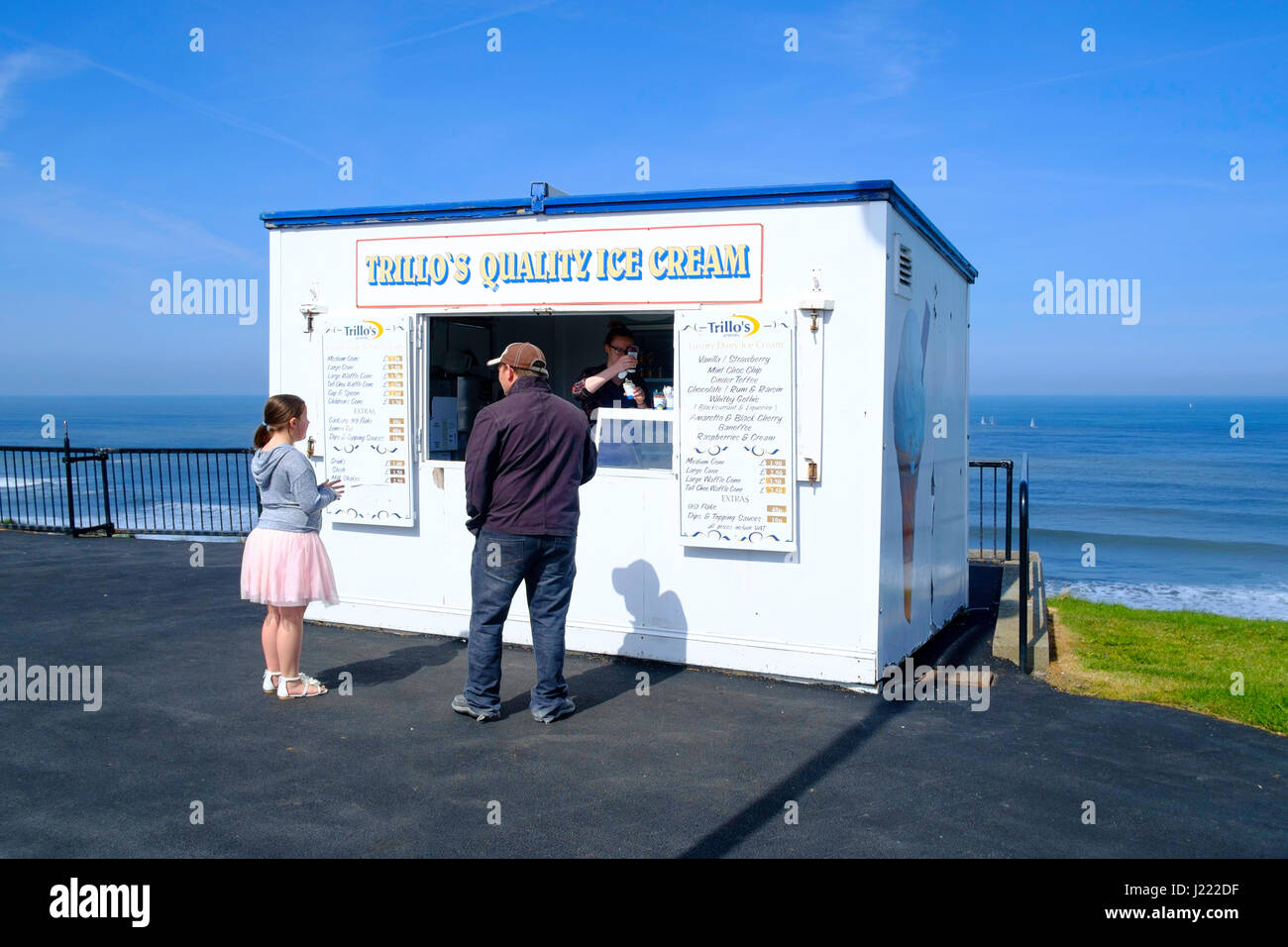 Ein Mann, ein Eis zu kaufen, für ein junges Mädchen in Trillo Eis-Hütte am Whitby West Cliff Stockfoto