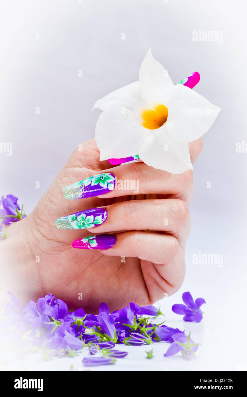 Hand mit Nägeln wieder aufgebaut und geschmückt mit bunten Blumen bringen  blauen und weißen Blumen auf weißem Hintergrund, schöne Neuheit für  Frühling und Sommer Stockfotografie - Alamy