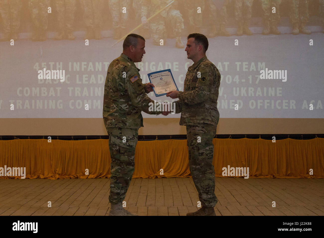 CPL. Riley Swan, ein Mitglied der 45. Infanterie-Brigade Combat Team und der distinguished Honor Absolvent der 7. Armee Training Befehl Unteroffizier Academy Leader Grundkurs 704-17, präsentiert Command Sergeant Major Bret A. Mellott, die Senior trat Staatsoberhaupt der Joint Multinational Readiness Center in Deutschland, mit einem Zertifikat der Anerkennung während der Klasse Abschlussfeier am Yavoriv Combat Training Center auf der internationalen Friedenssicherung und Security Center , in der Nähe von Yavoriv, Ukraine, am 22. April. (Foto von Sgt. Anthony Jones, 45. Infanterie Brigade Combat Team) Stockfoto