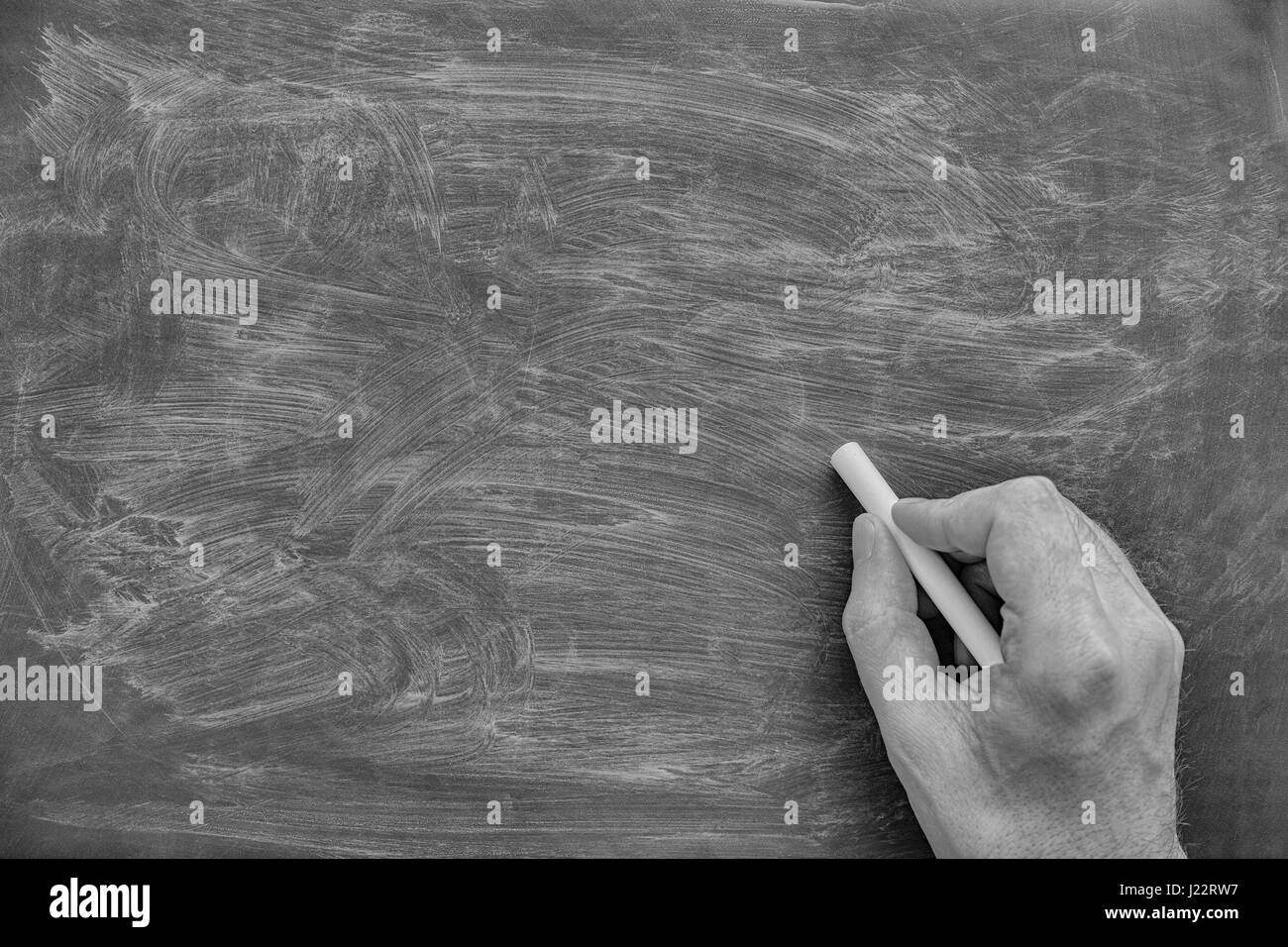 Tafel und Hand mit Kreide. Schwarz und weiß. Hautnah. Stockfoto