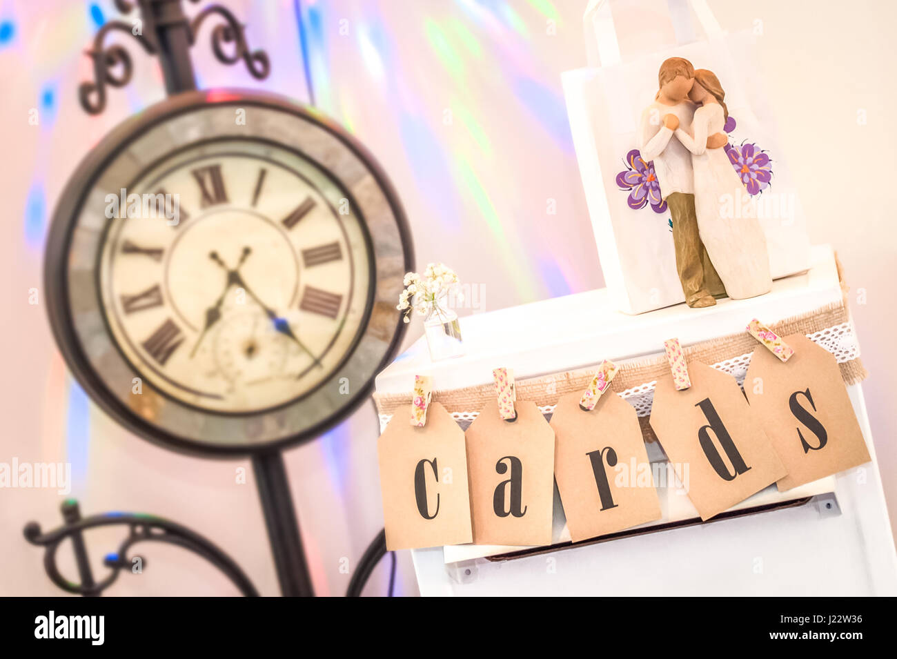 Sammlung von dekorativen Hochzeit Display Ornamente mit Vintage Uhr im Hintergrund Stockfoto