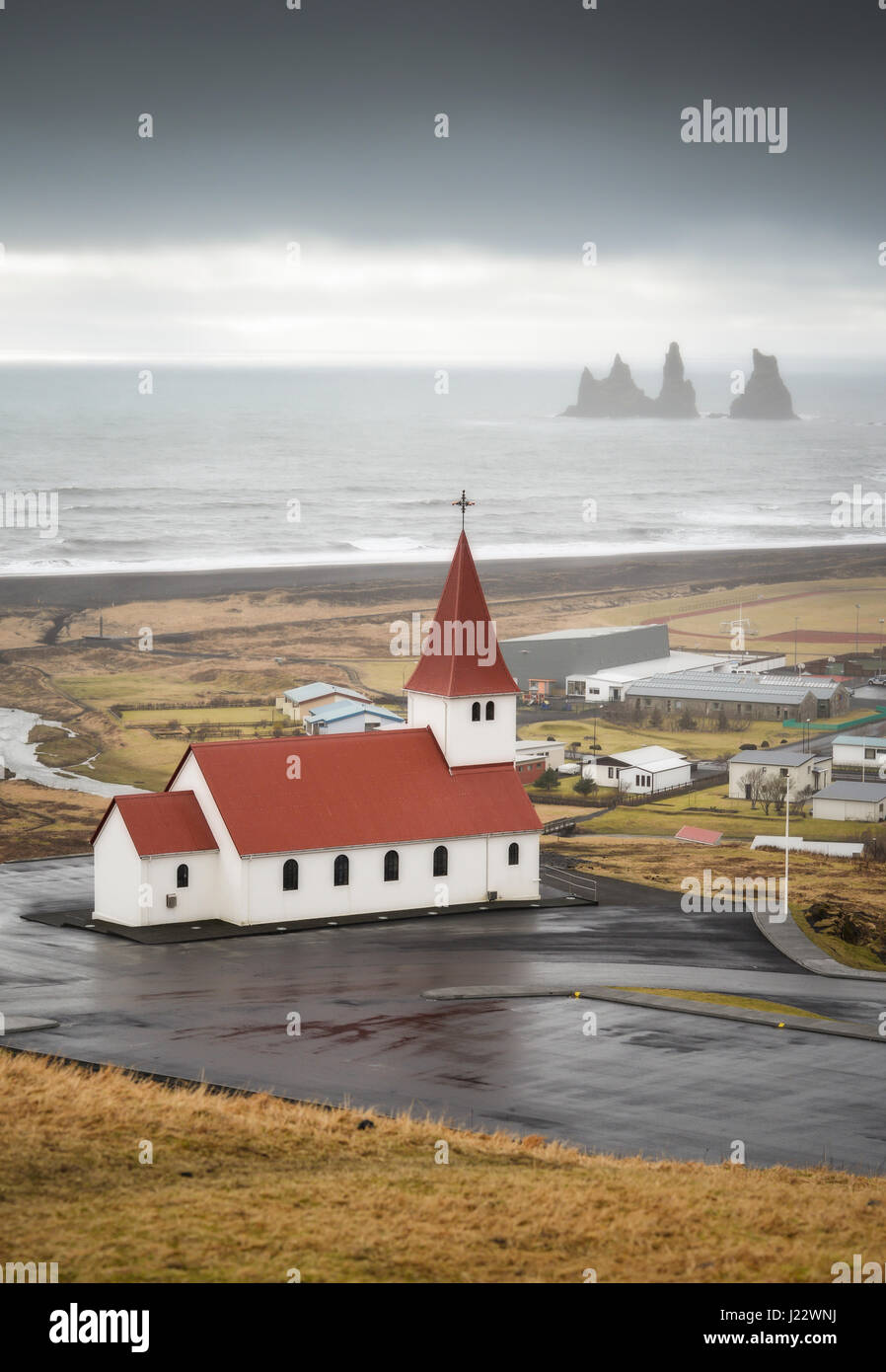 Island, Vik, Kirche und Stein Trolle im Hintergrund Stockfoto