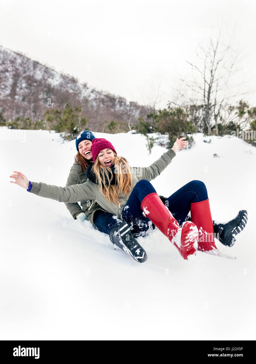 Zwei beste Freunde, die Spaß mit einem Schlitten im Schnee Stockfoto