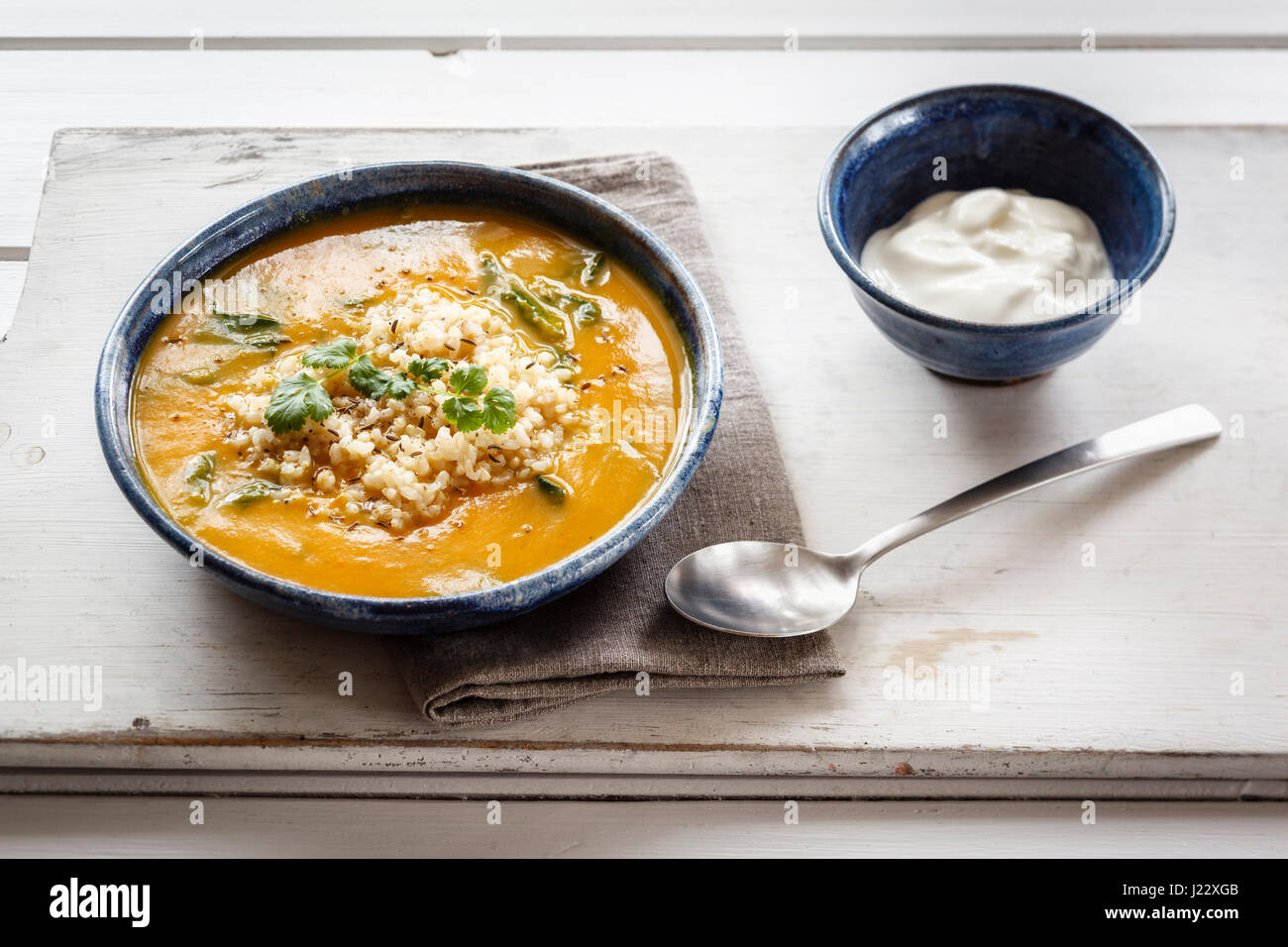 Sahne Kürbis Suppe mit brauner Reis und Spinat Stockfoto