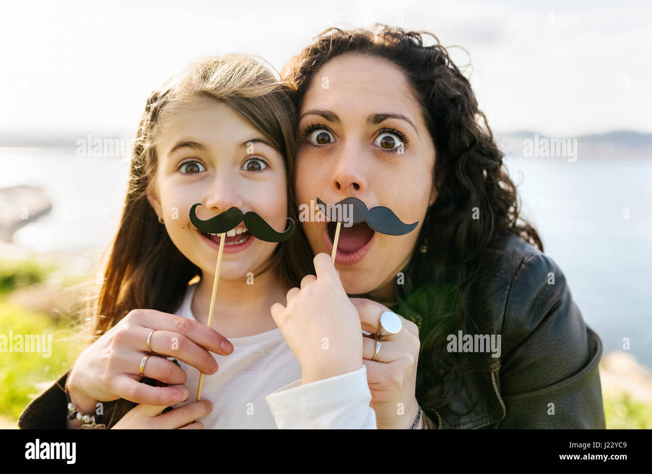 Mutter und Tochter haben Spaß Holding gefälschte Schnurrbart Stockfoto