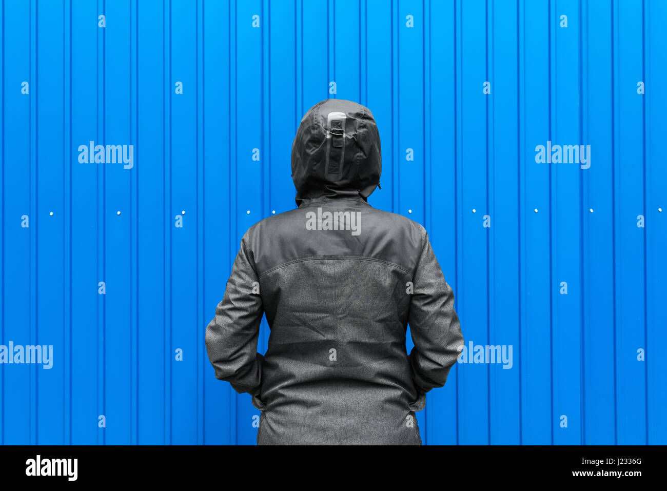 Probleme und Hindernisse im Leben, Frau in Kapuzen Winterjacke vor der Wand eine Herausforderung Stockfoto