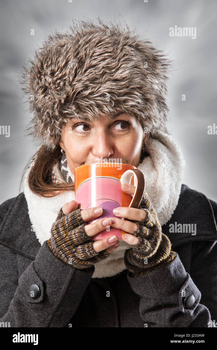 Frau in ein heißes Getränk aus einem Becher trinken warme Winterkleidung Stockfoto