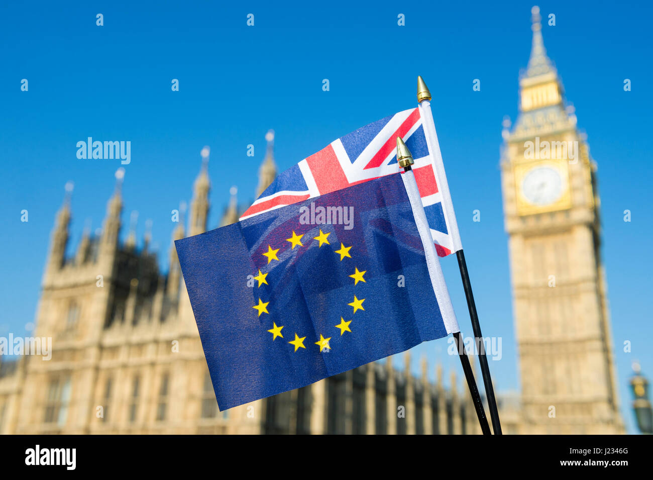 Flaggen der EU und UK Großbritannien fliegen gemeinsam solidarisch in strahlend blauen Himmel vor den Houses of Parliament, Westminster in London Stockfoto
