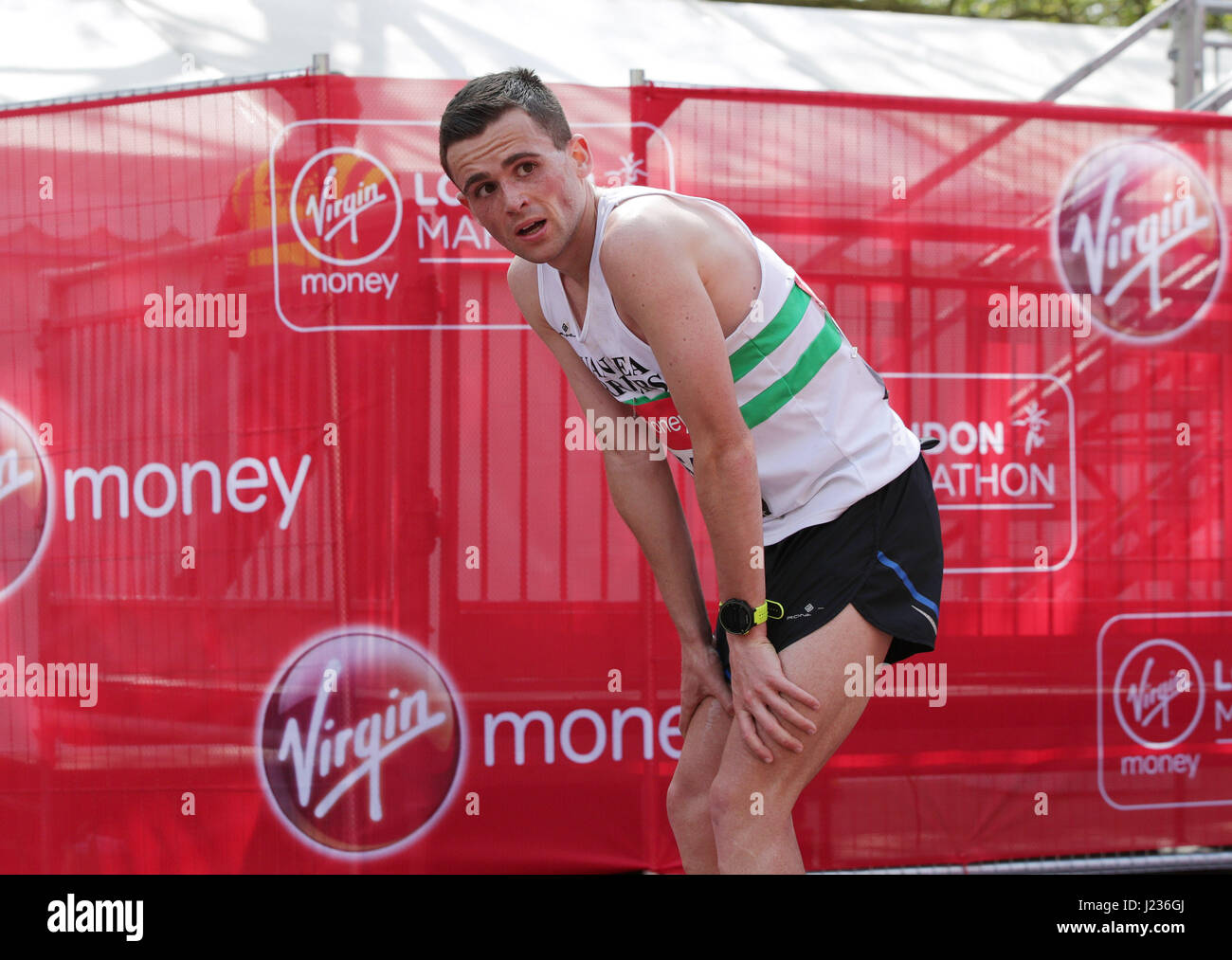 Josh Griffiths, ein 23-Year-Old Club Läufer vom Kreuz Hände ist der erste britische Läufer über die Ziellinie auf der Mall - Rang 13. insgesamt - im Virgin Geld London-Marathon, London. Stockfoto