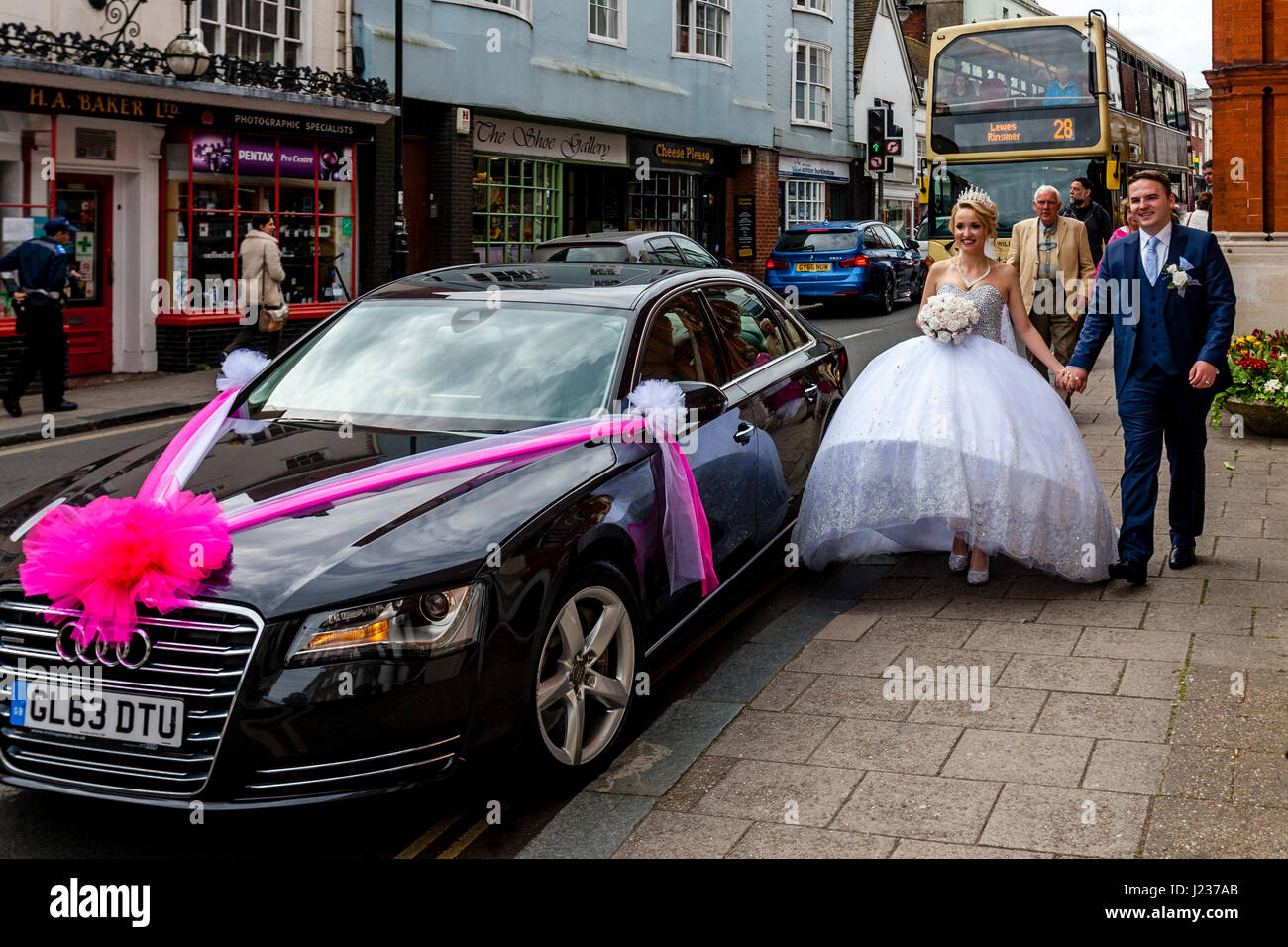 Ein frisch verheiratetes junges Paar erhalten Sie in ihrem Auto, Lewes, Sussex, UK Stockfoto