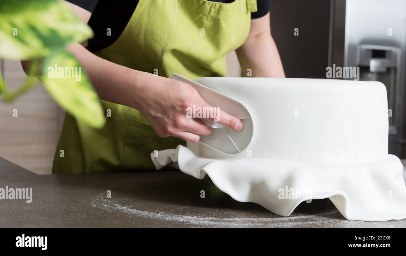 Nahaufnahme der Frau in Bäckerei dekorieren Kuchen mit Royal icing Stockfoto