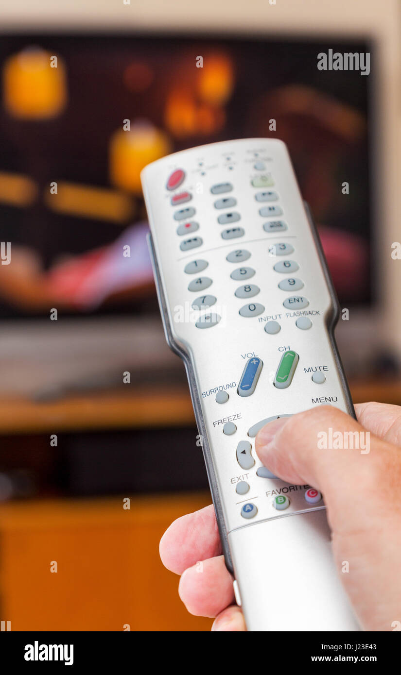 Person mit einer TV-Fernbedienung Stockfoto