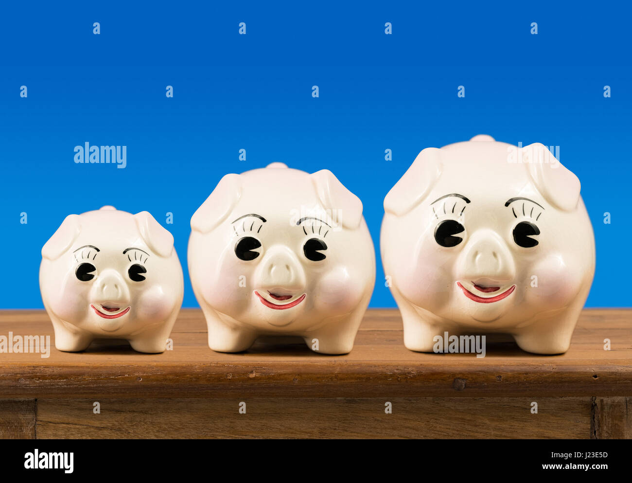 Drei Sparbüchsen immer größer in einer Reihe Stockfoto