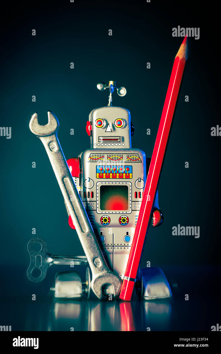 Ein Spielzeugroboter besitzt einen Schraubenschlüssel und einen roten Stift Stockfoto
