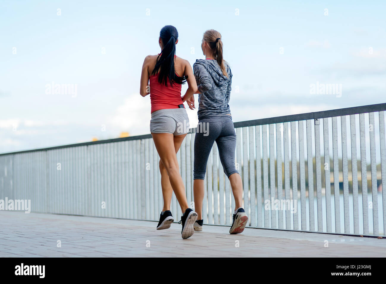 Zwei Frauen, die durch Joggen in Stadt Stockfoto