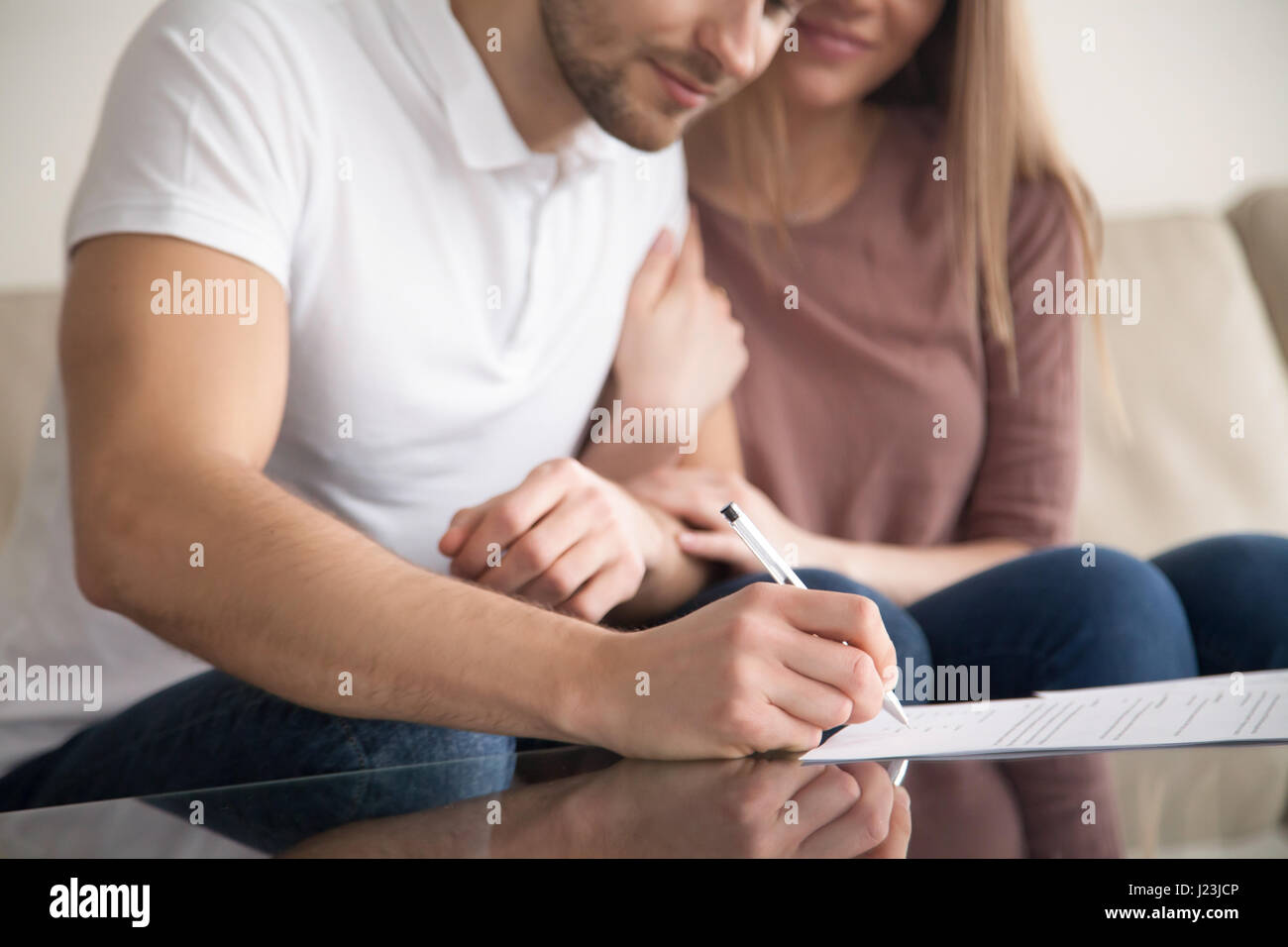 Nahaufnahme des jungen Brautpaares Unterzeichnung Papiere, Eigentum zu erwerben, Stockfoto