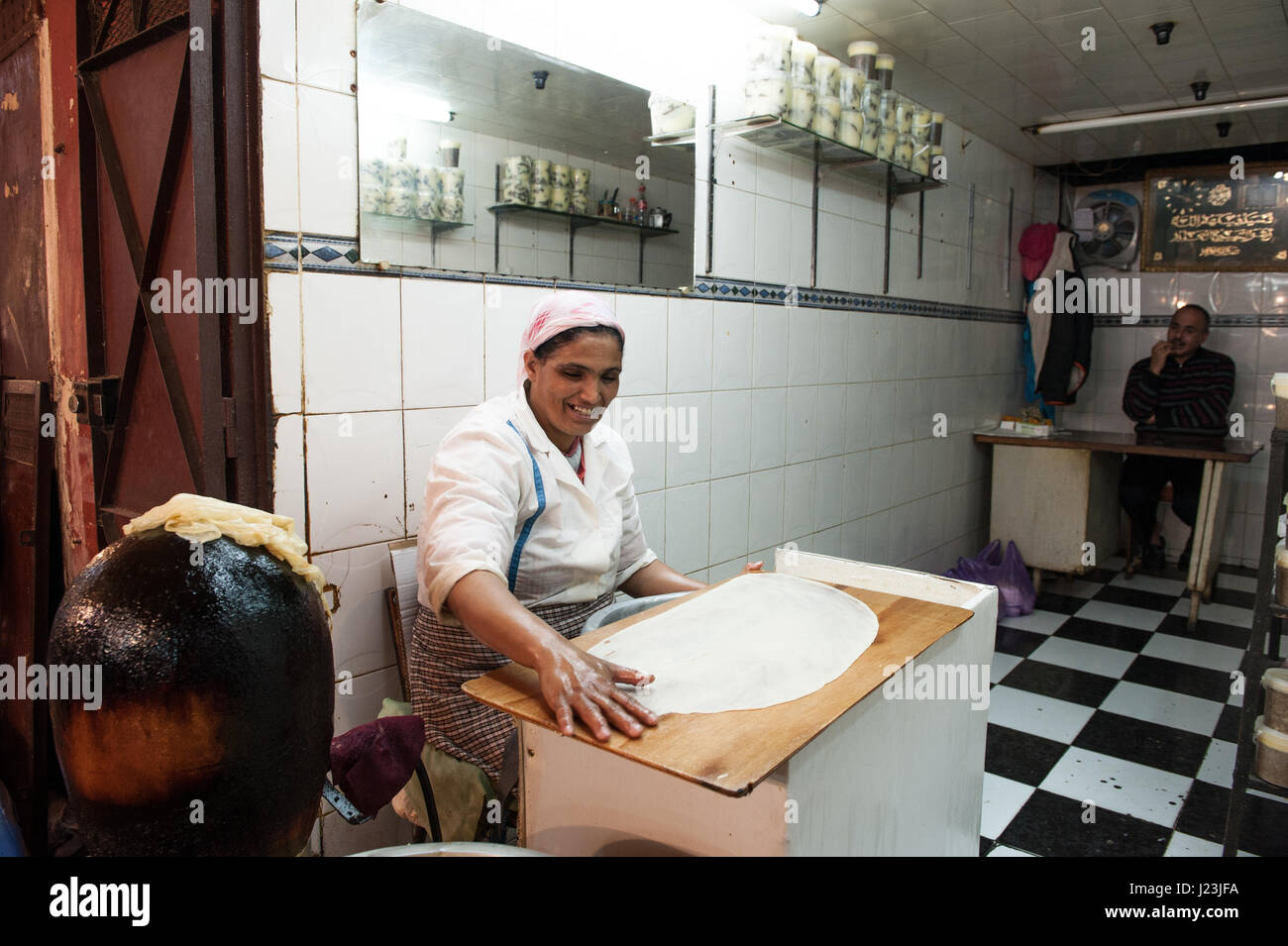 Nordafrika, Marokko, Fez. Pastilla Vorbereitung Fes Marokko. Die Frau macht die Pastilla und die Männer im Hintergrund wartet auf Kunden. Stockfoto