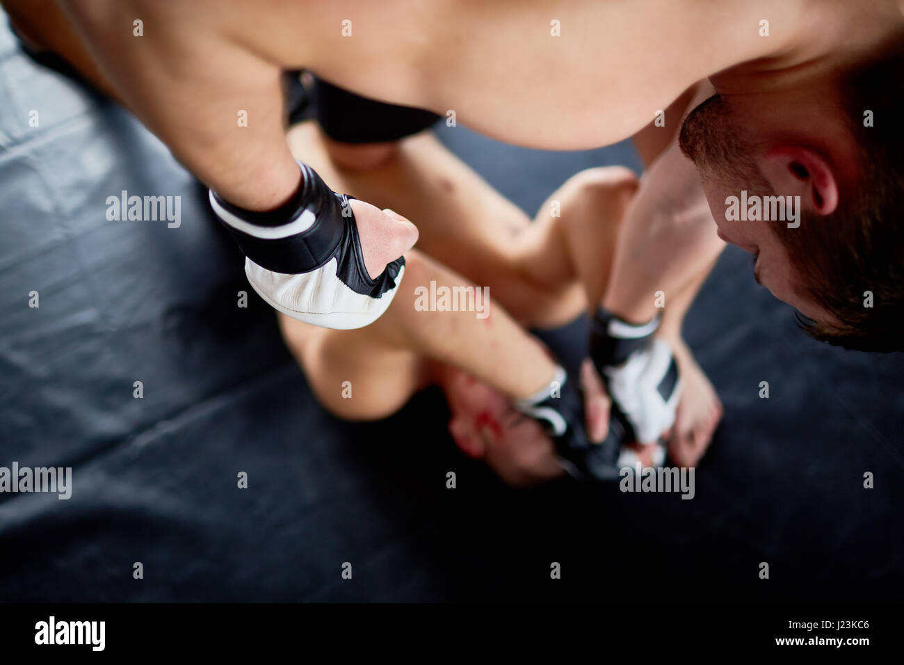 Über Ansicht-Porträt von Profi-Wrestler im Kampf mit Gegner trifft ihn im Gesicht am Boden, Blut gesehen Stockfoto