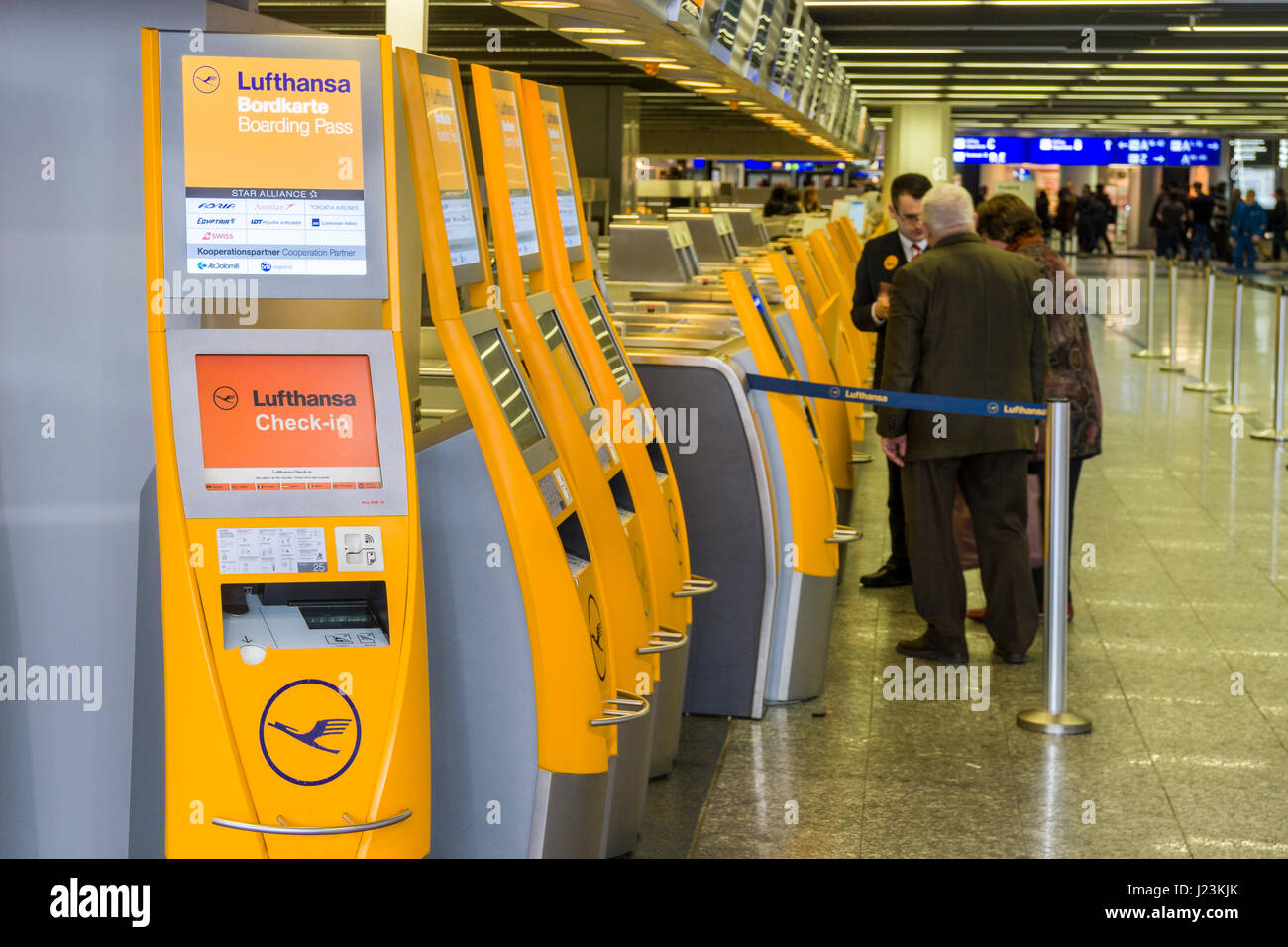 Ein Mann und eine Frau stehen am Lufthansa Self Check-In-Terminal am Frankfurter Flughafen Stockfoto