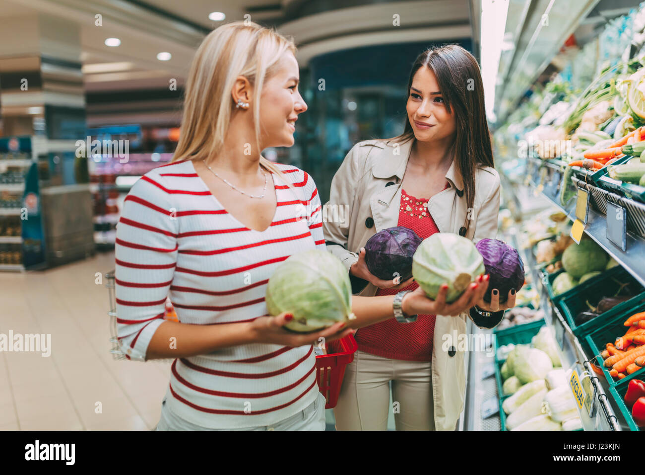 Schöne Frauen Obst und Gemüse im Supermarkt einkaufen Stockfoto