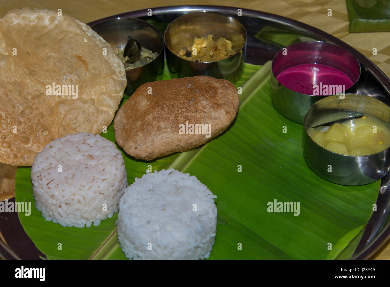 Indien, Bundesstaat Kerala, Villanjam aka Vizhinjam. Typisches Kerala Saday Mittagessen, vegetarisches Essen mit Reis und Nan-Brot, serviert auf Banane Blatt. Stockfoto