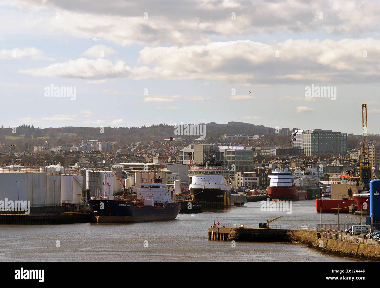 ABERDEEN, Schottland - 30. März 2017: der Eingang zum Aberdeen Harbour, Schottland, mit Blick über Stadt, Lagertanks und festgemachten Schiffe Stockfoto