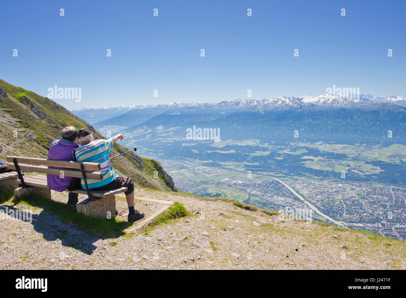 Zwei alte Männer sitzen auf einer Holzbank, bewundern Sie den Panoramablick auf die Berge vom Hafelekarspitze, Tirol, Österreich Stockfoto