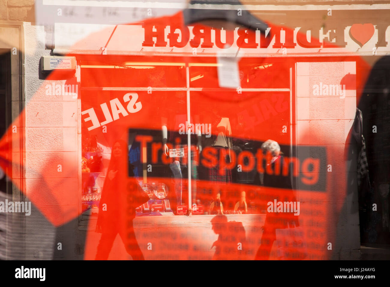 Schaufenster in der Royal Mile in Edinburgh, Schottland, UK, Großbritannien. Rotes T-shirt von Trainspotting mit der Reflexion des ich liebe Edinburgh Shop im Hintergrund. Stockfoto