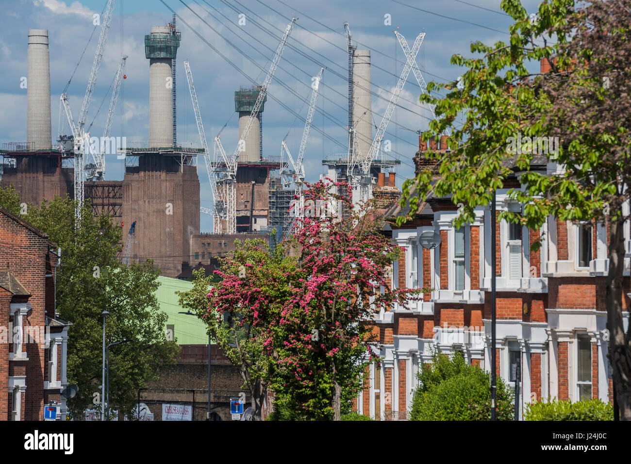 London, UK. 25. April 2017. Die Krane und Schornsteine Webstuhl über einen terrassenförmig angelegten Wohnstraße in Clapham alten Towmn-den Wiederaufbau des Battersea-Kraftwerk weiter Ion ein helles aber knackig Frühlingstag. London, 25. April 2017. Bildnachweis: Guy Bell/Alamy Live-Nachrichten Stockfoto