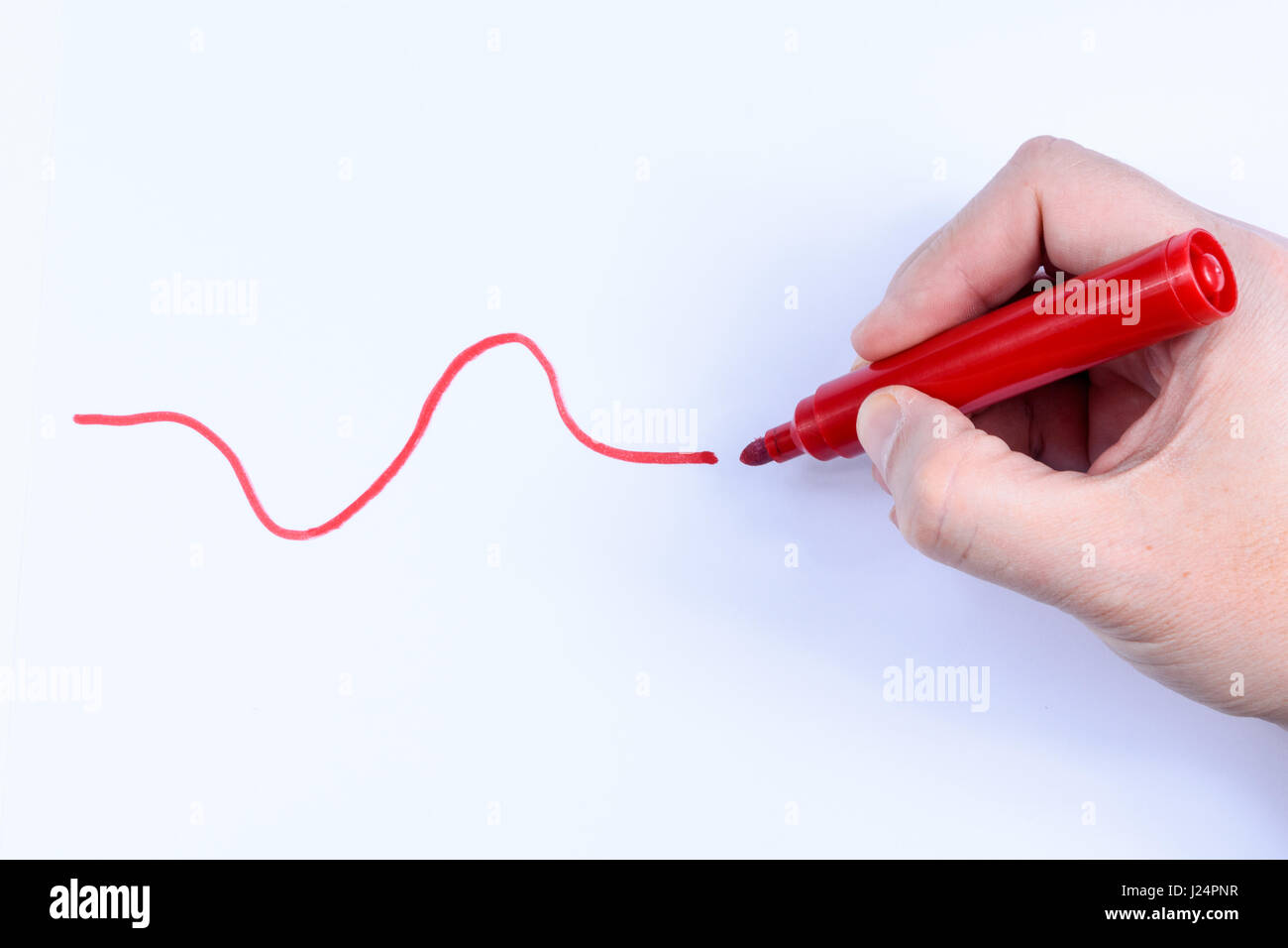 Hand, die einen roten Stift eine wellige Linie isoliert auf weißem Hintergrund Stockfoto