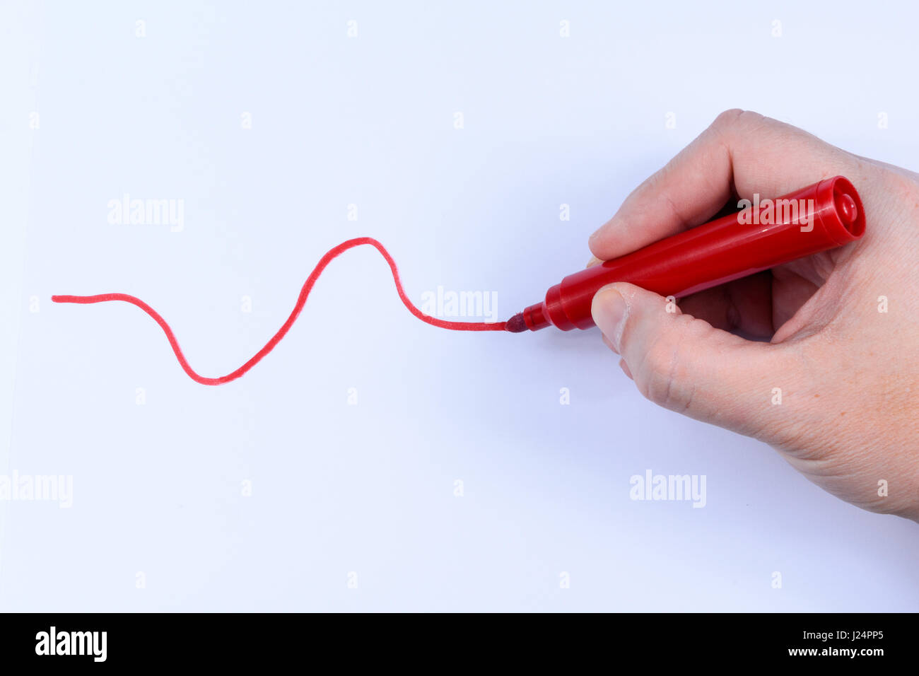 Hand, die einen roten Stift eine wellige Linie isoliert auf weißem Hintergrund Stockfoto