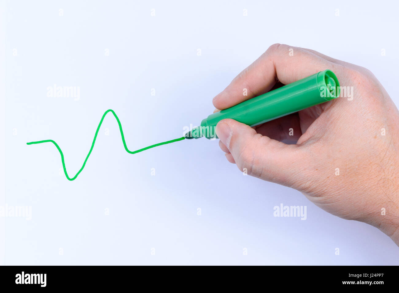 Hand mit einem grünen Stift eine wellige Linie isoliert auf weißem Hintergrund Stockfoto