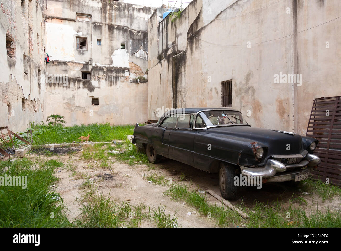 Ein klassisches amerikanisches Auto geparkt zwischen zwei Gebäuden in Havanna, Kuba. Stockfoto