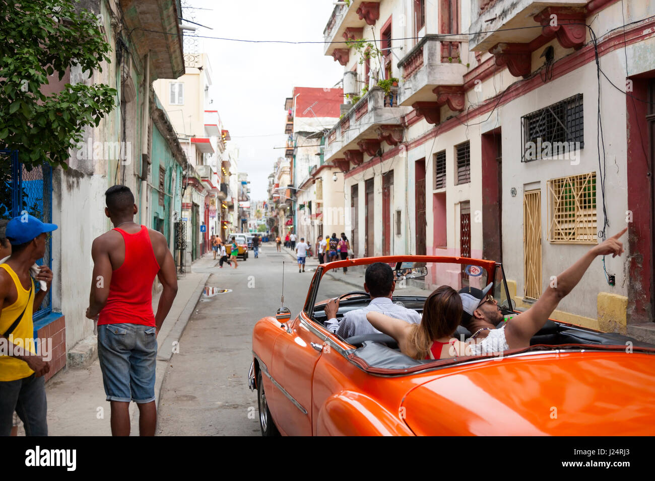 Touristen, die eine Fahrt in einem gepflegten amerikanischen Oldtimer in Havanna, Kuba. Stockfoto