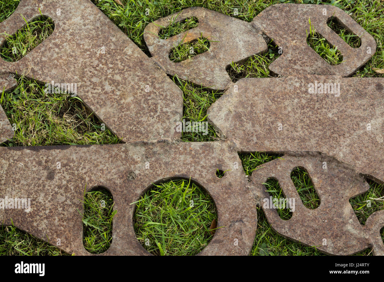 Einige Metall-Formen geschweißt zusammen zu legen, auf einigen grünen Rasen. Stockfoto