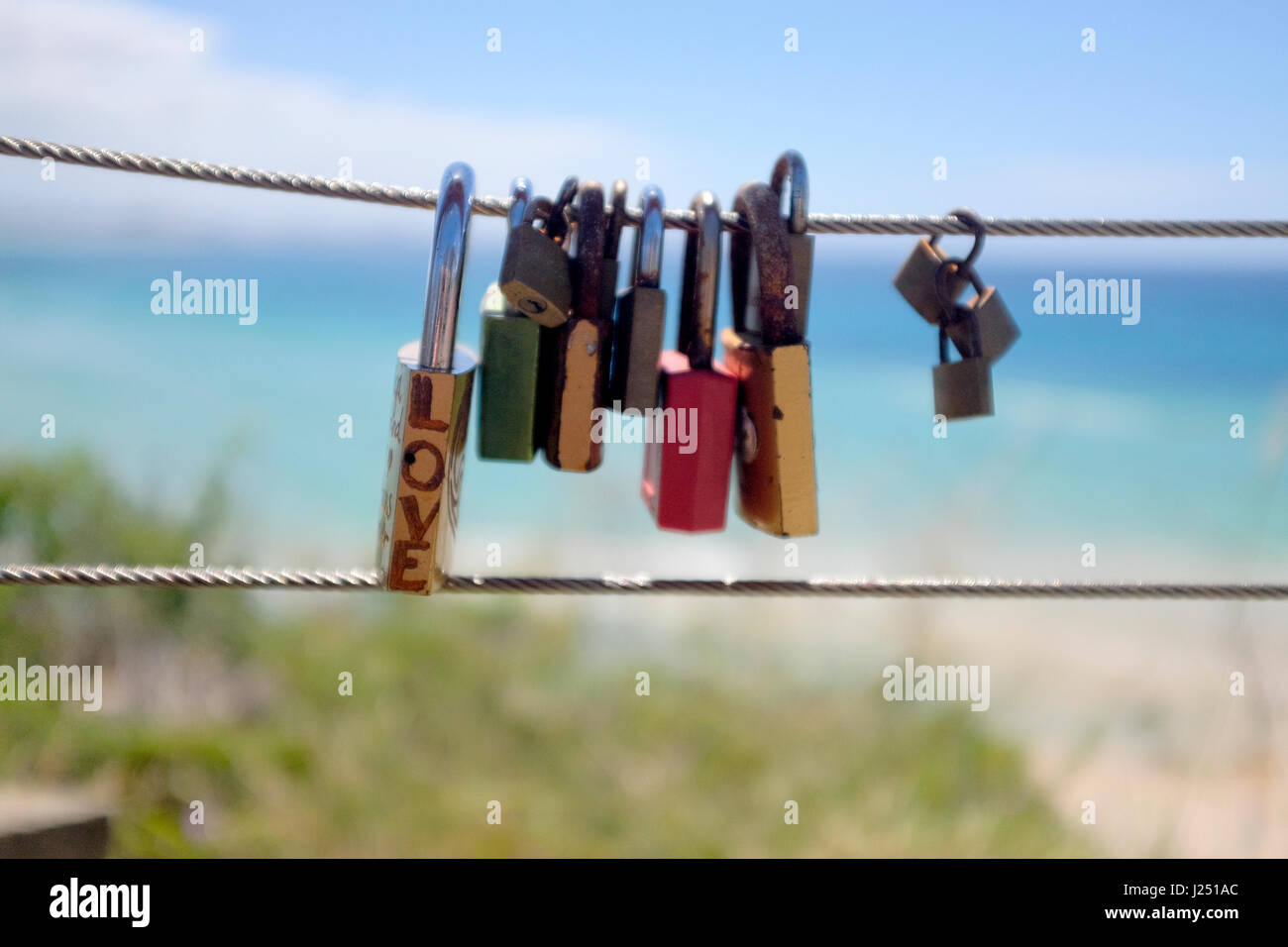 Vorhängeschlösser graviert mit "Love" als Symbol der romantischen Liebe mit Handlauf Draht am Meer an der Ostküste Australiens am Kirra Hill, Coolangatta verbunden Stockfoto