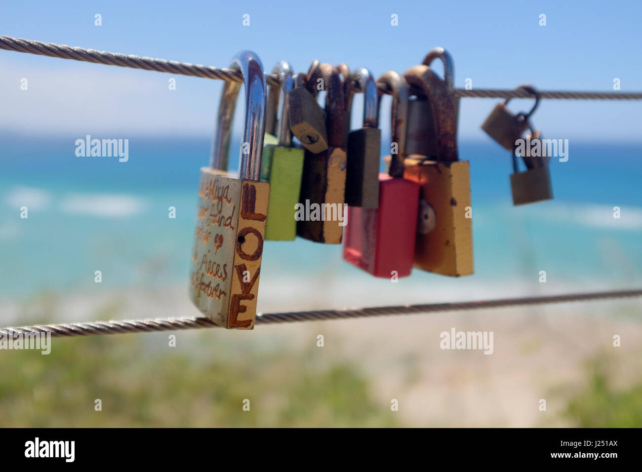 Vorhängeschlösser graviert mit "Love" als Symbol der romantischen Liebe mit Handlauf Draht am Meer an der Ostküste Australiens am Kirra Hill, Coolangatta verbunden Stockfoto