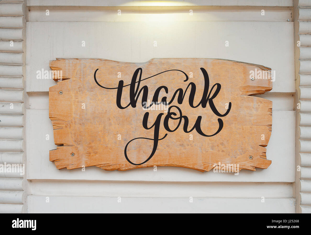 Leere Holzplatte auf Wand und Text Thank You. Kalligraphie-Schriftzug Hand zeichnen Stockfoto