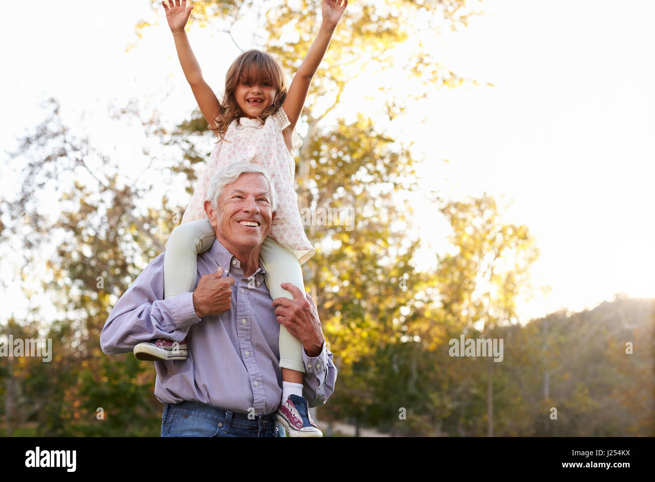 Großvater mit Enkelin eine Schulter fahren im Park Stockfoto