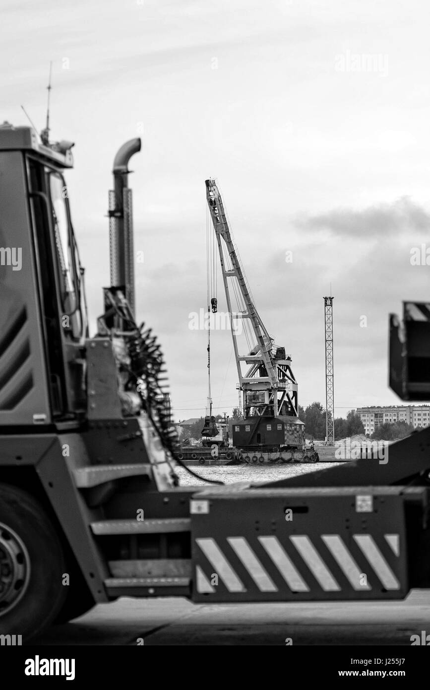 Hinter dem LKW Silhouette sichtbar schwimmende Plattform mit der Hafenkran. Stockfoto