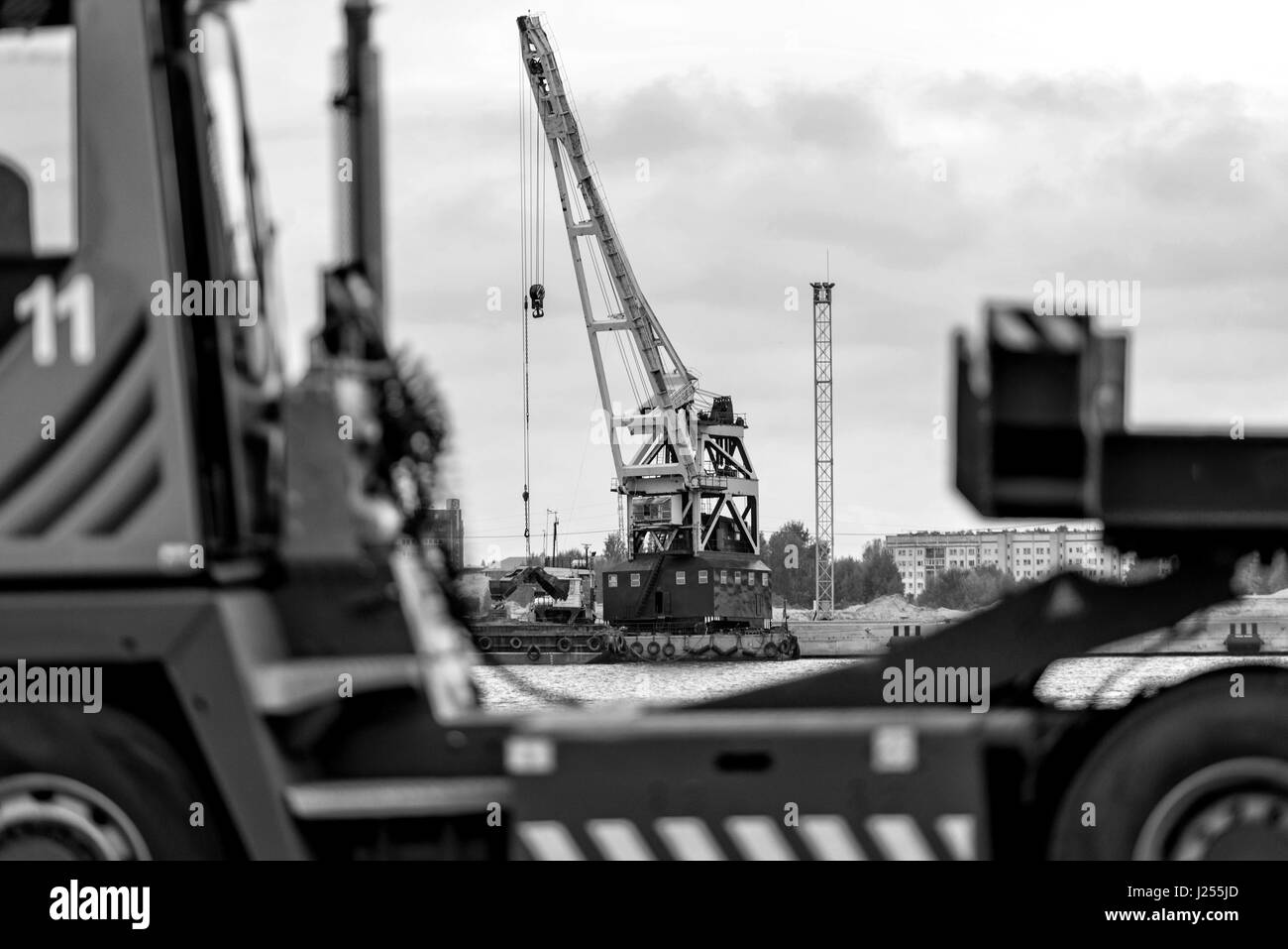 Hinter dem LKW Silhouette sichtbar schwimmende Plattform mit der Hafenkran. Stockfoto